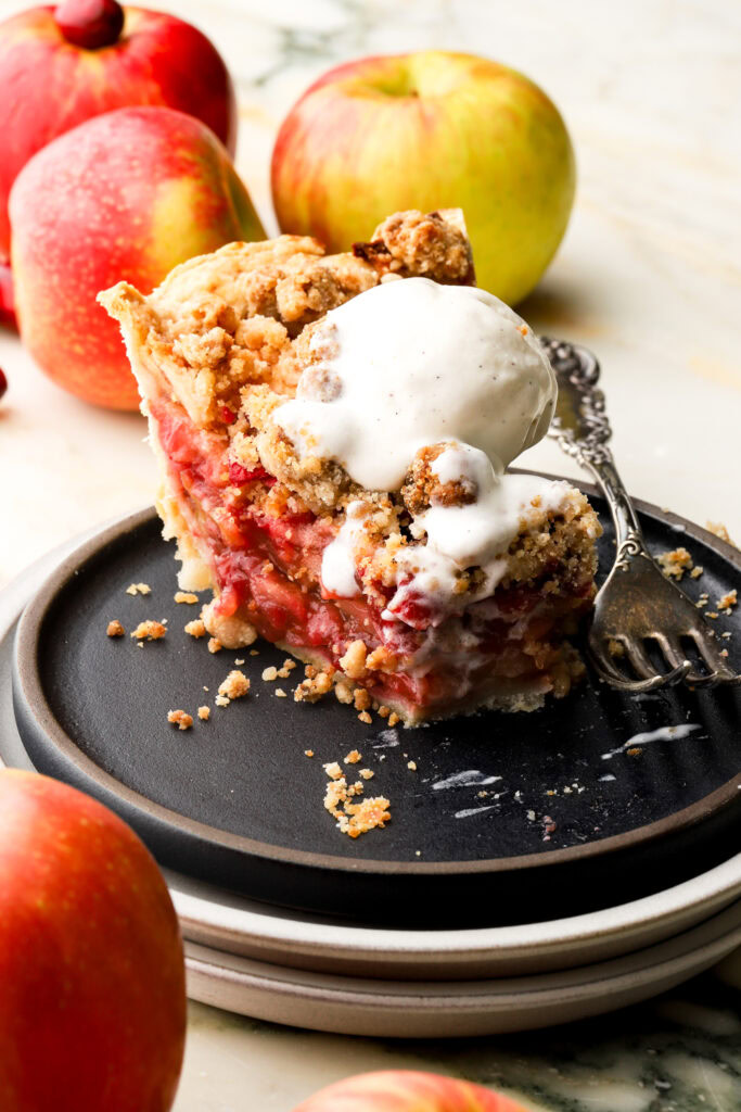 slice of apple cranberry pie with ice cream on top