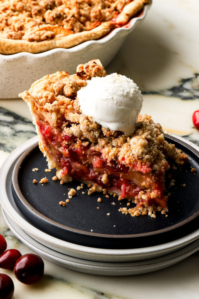 slice of apple cranberry pie with ice cream on top