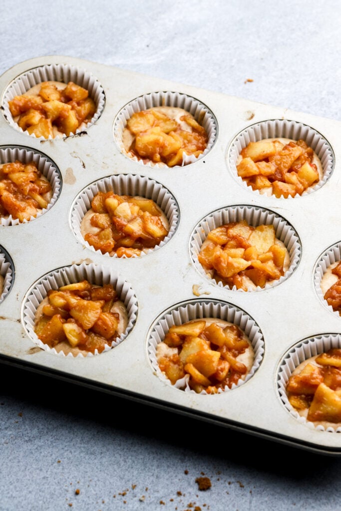 apple pie topping on top of cupcakes before baking
