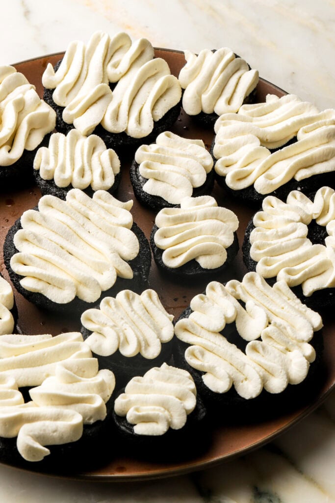 mascarpone cream piped on top of chocolate espresso donuts