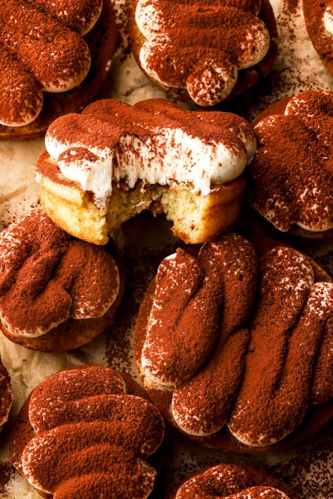 a bite taken out of tiramisu donuts on a tray