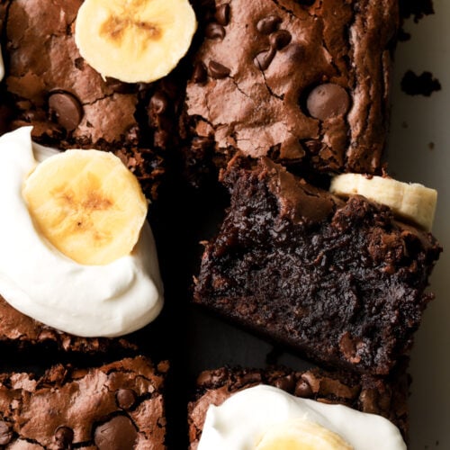 banana brownies topped with whipped cream and banana slices
