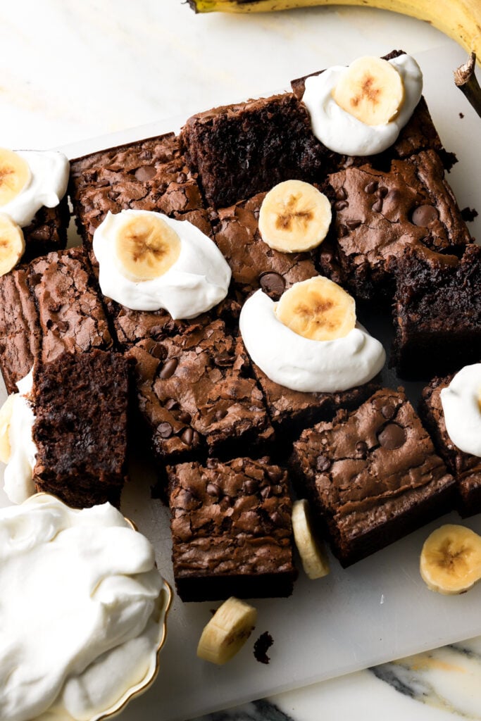 banana brownies topped with whipped cream and banana slices
