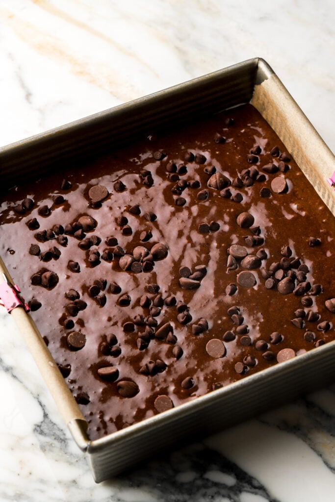 banana brownie batter in pan with chocolate chips