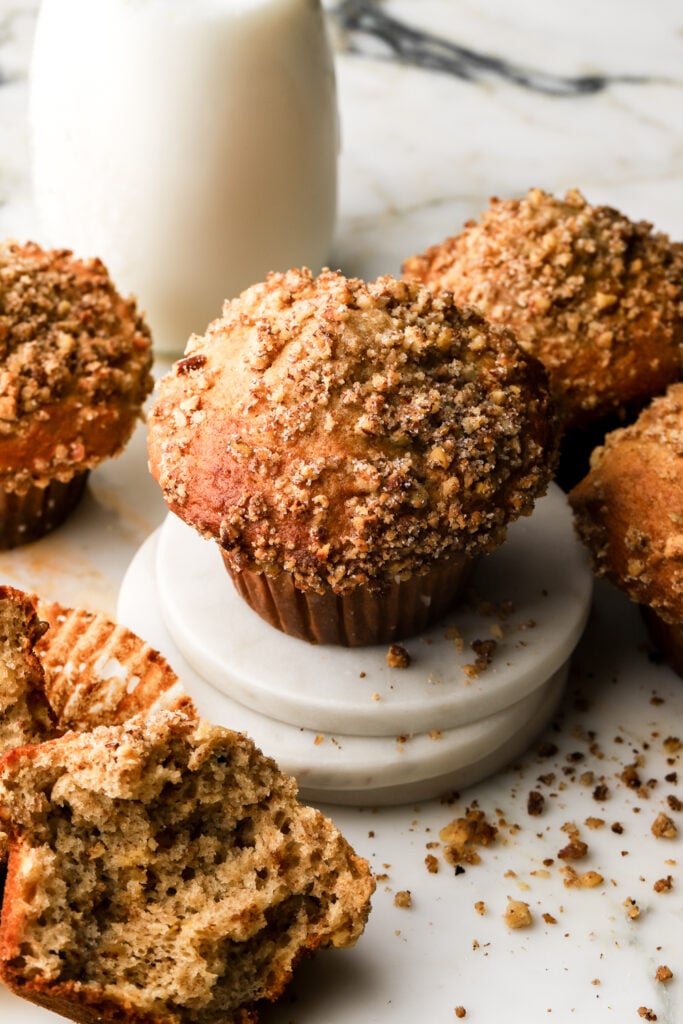 banana nut muffins on a coaster with a glass of milk
