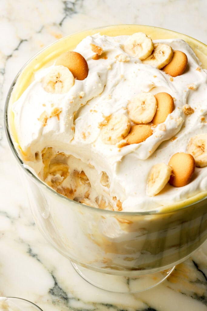 close up of banana pudding in a trifle dish with a scoop removed