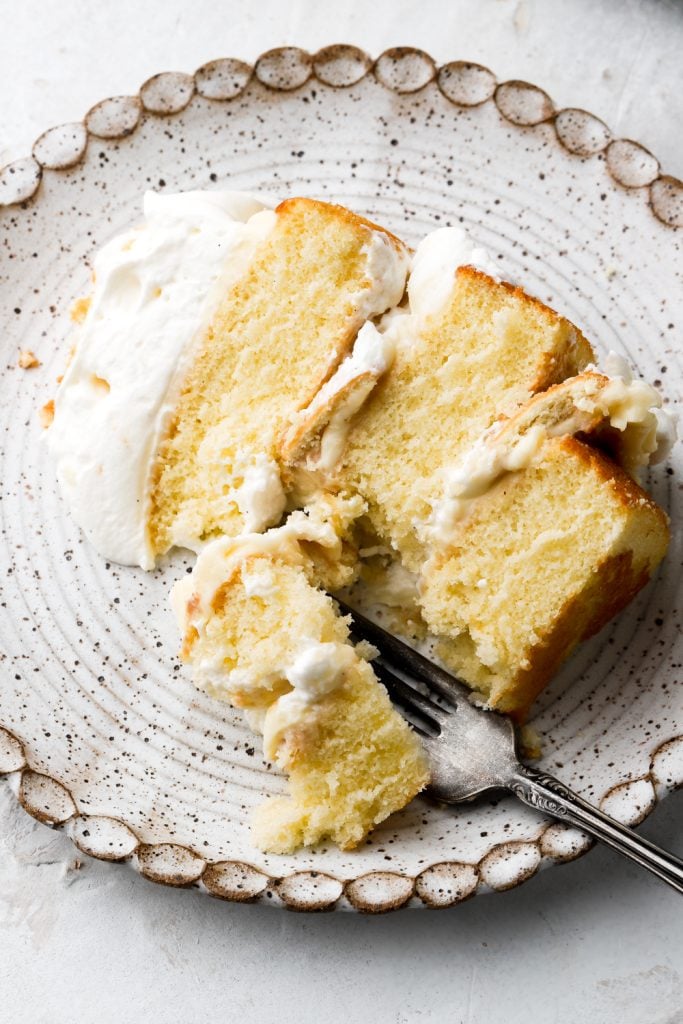 slice of banana pudding cake on a plate with a bit taken out