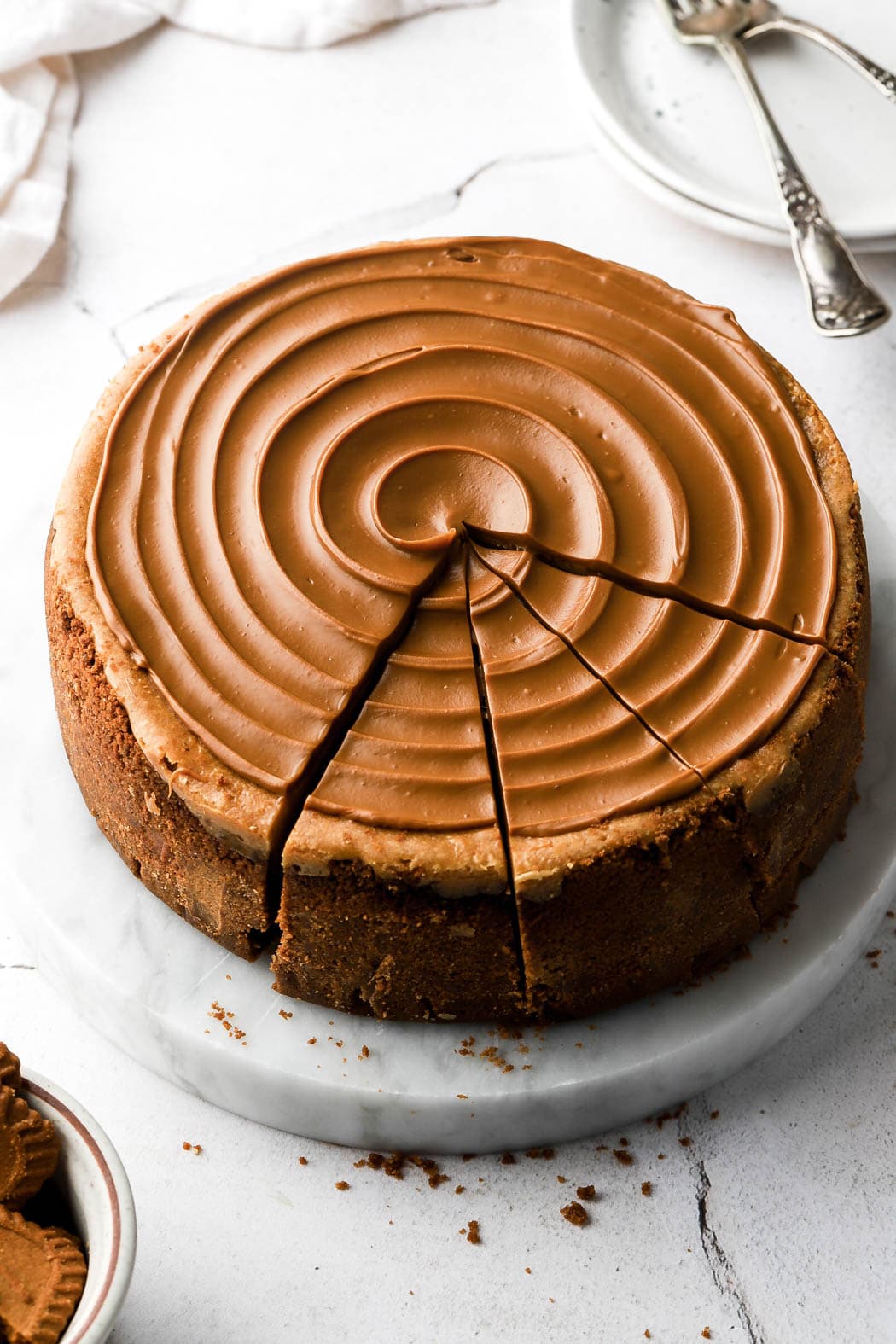 cheesecake with cookie butter swirl on top and three slices cut