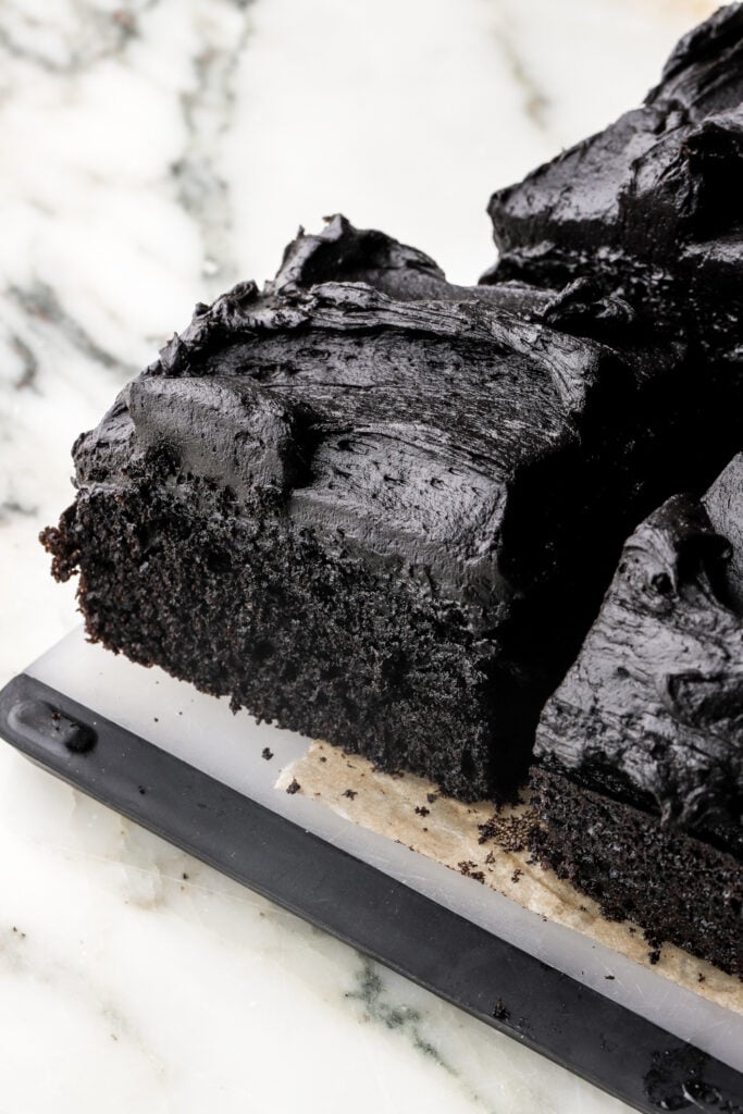slice of black cocoa sheet cake on a cutting board
