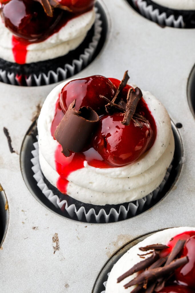 close up of cherry topping on a black forest cupcake