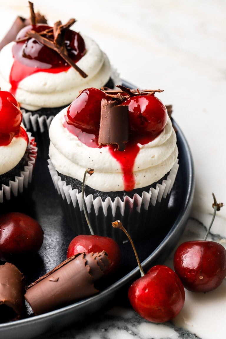 black forest cupcakes on a plate with cherries