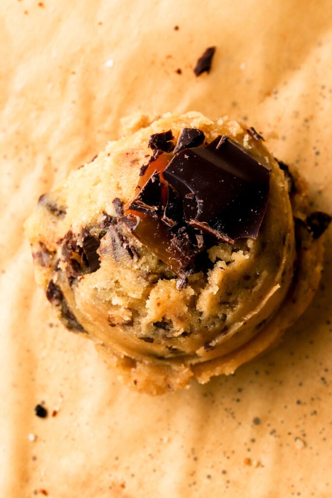 close up of brown butter chocolate chip cookie dough with chocolate chunk on top