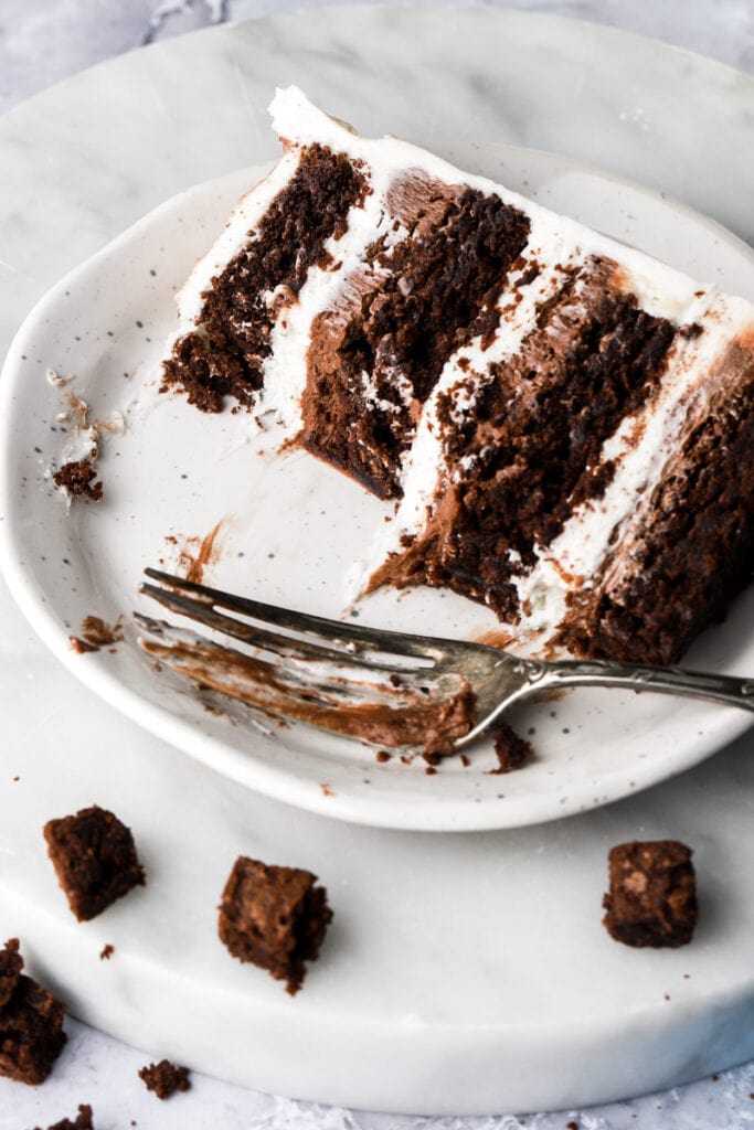 slice of brownie cake on a plate with a fork and little brownies