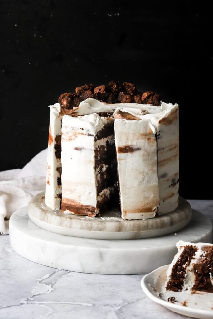 cake frosted with white frosting and brownies on top