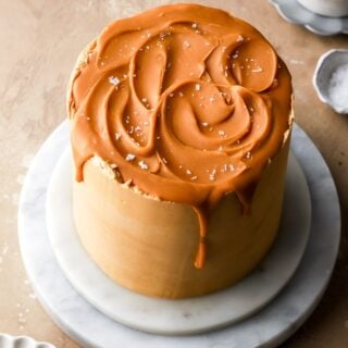 6 inch butterscotch cake on a marble board topped with butterscotch ganache swirls and sea salt flakes