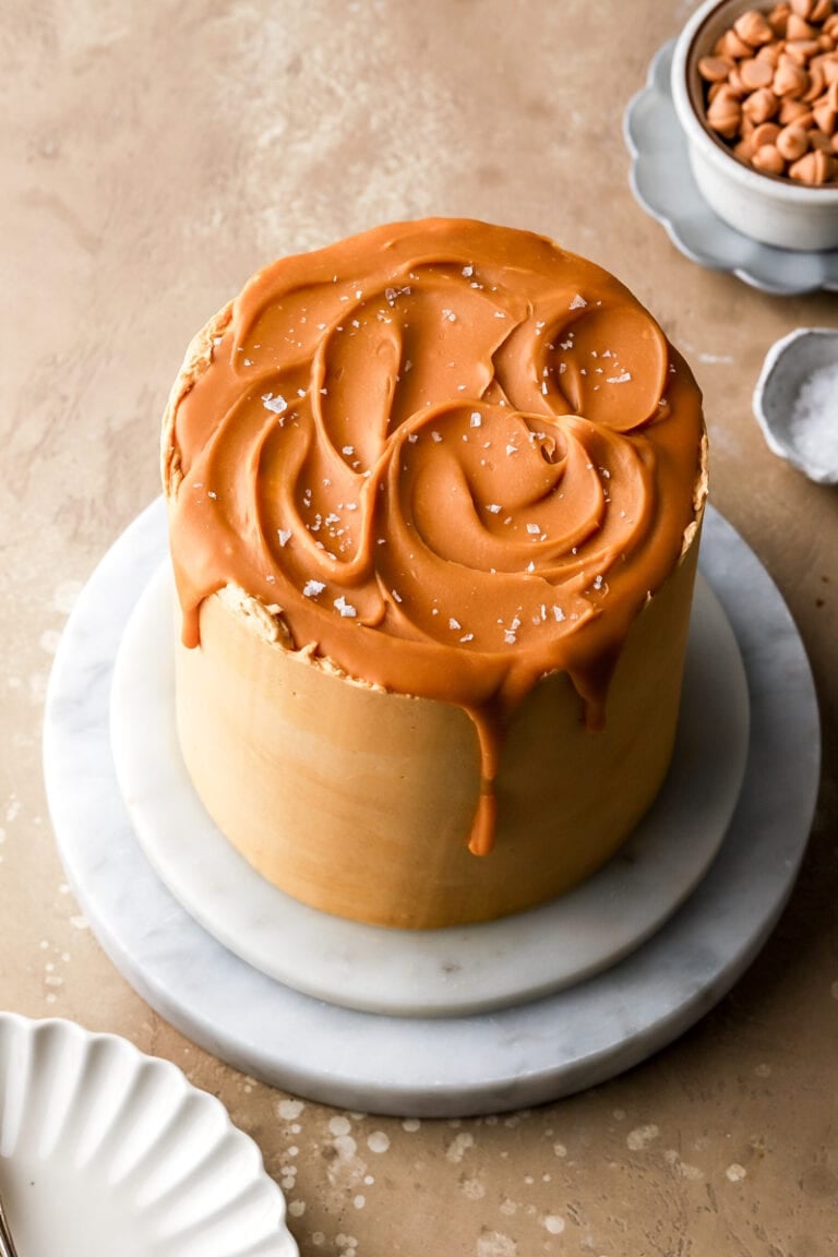 6 inch butterscotch cake on a marble board topped with butterscotch ganache swirls and sea salt flakes