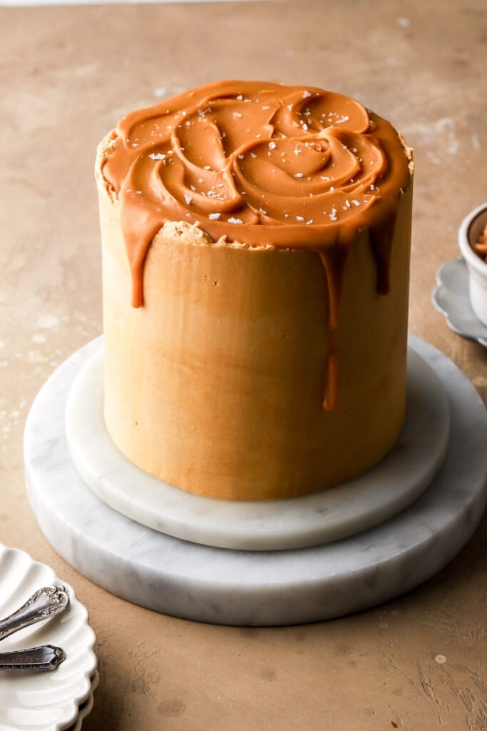 butterscotch cake with butterscotch drip and sea salt flakes on a marble board