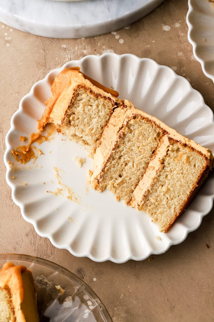 slice of butterscotch cake on a plate with a bite taken out