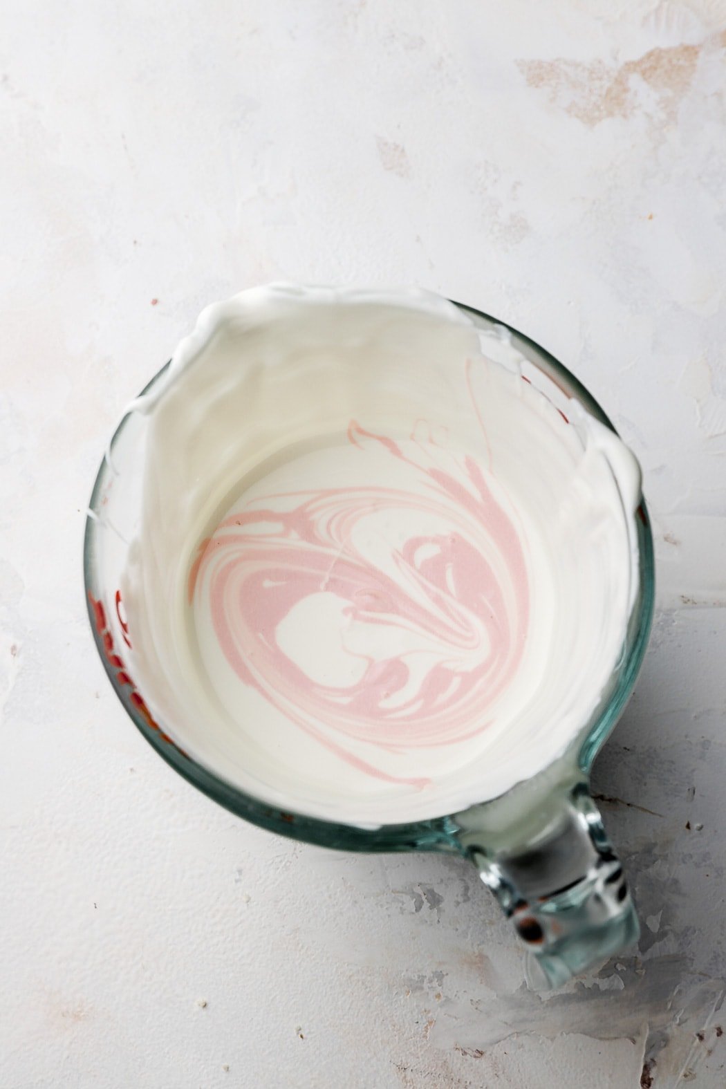 drizzle a little colored white chocolate into the white, then dip, repeat if needed