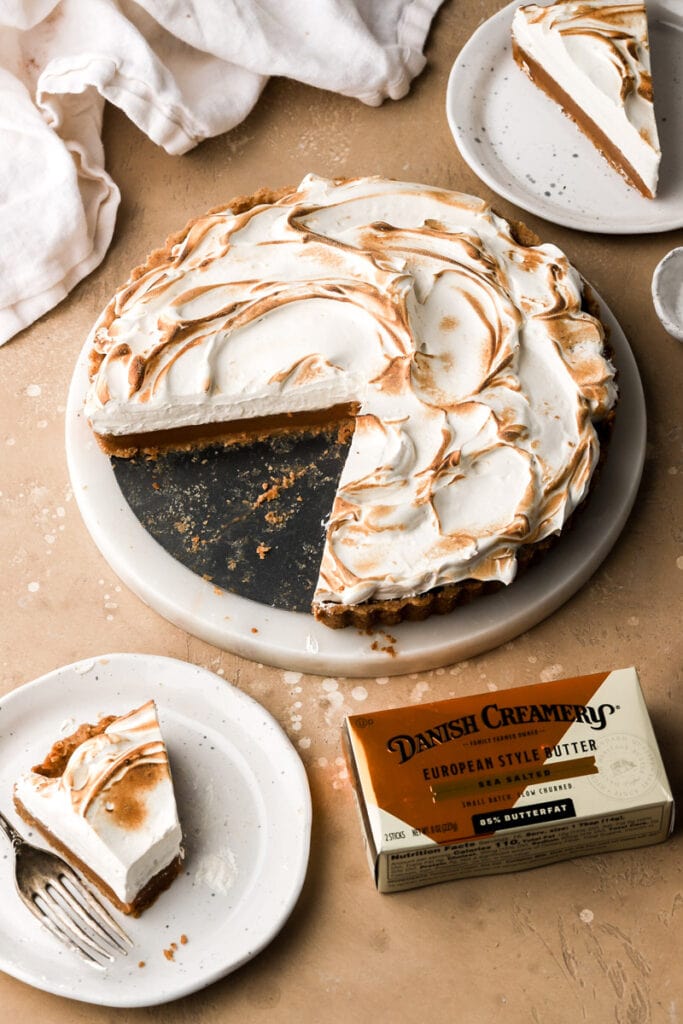 Caramel tart with two slices cut out and danish creamery butter box