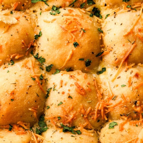 cheese bread rolls in pan topped with herbs