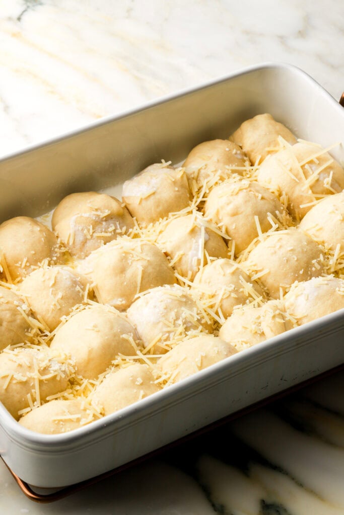bread rolls after second proof, topped with cream and parmesan