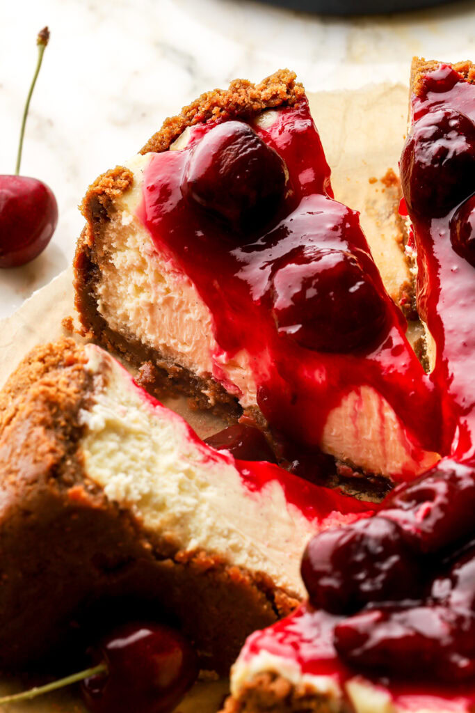 slices of cherry cheesecake cut out but still on the parchment