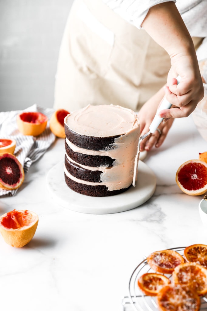 frosting dark chocolate cake with blood orange buttercream