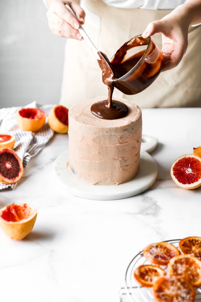 pour chocolate ganache on top of layered cake