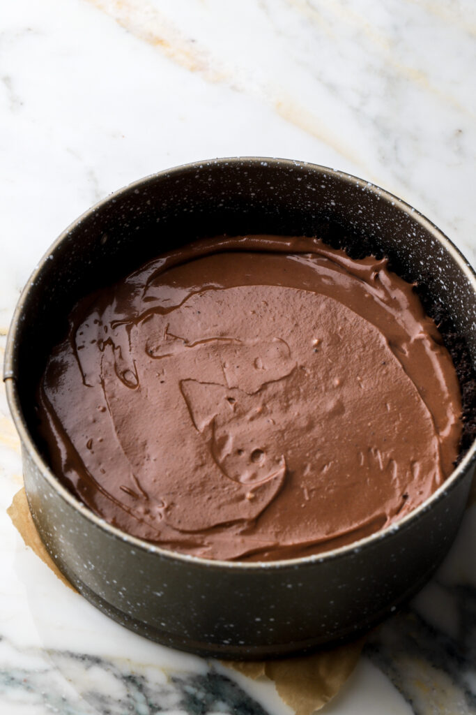 cheesecake batter poured into the oreo crust