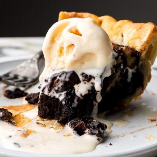 slice of chocolate pecan pie on a plate with ice cream