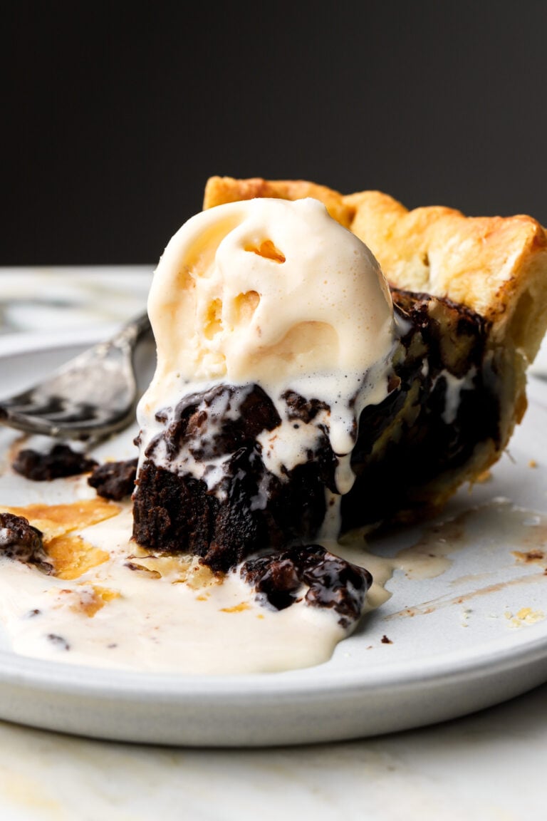 slice of chocolate pecan pie on a plate with ice cream