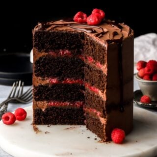 four layers of chocolate cake with chocolate ganache frosting and raspberry filling