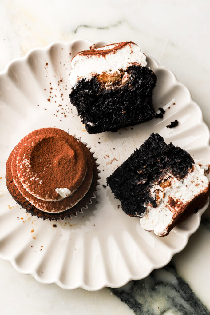 chocolate tiramisu cupcake sliced in half on a plate