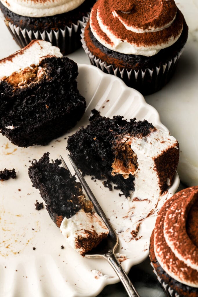 chocolate tiramisu cupcake sliced in half and fork cutting into it
