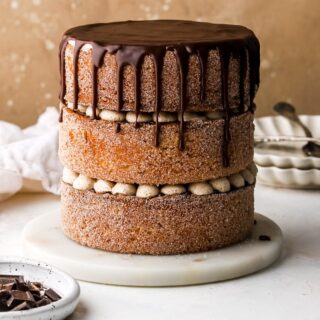 three layer churro cake covered in cinnamon sugar and chocolate sauce