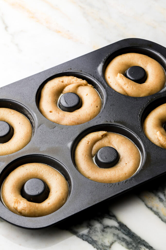 donut batter piped into donut molds