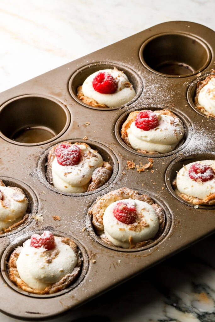 tarts topped with fruit and powdered sugar