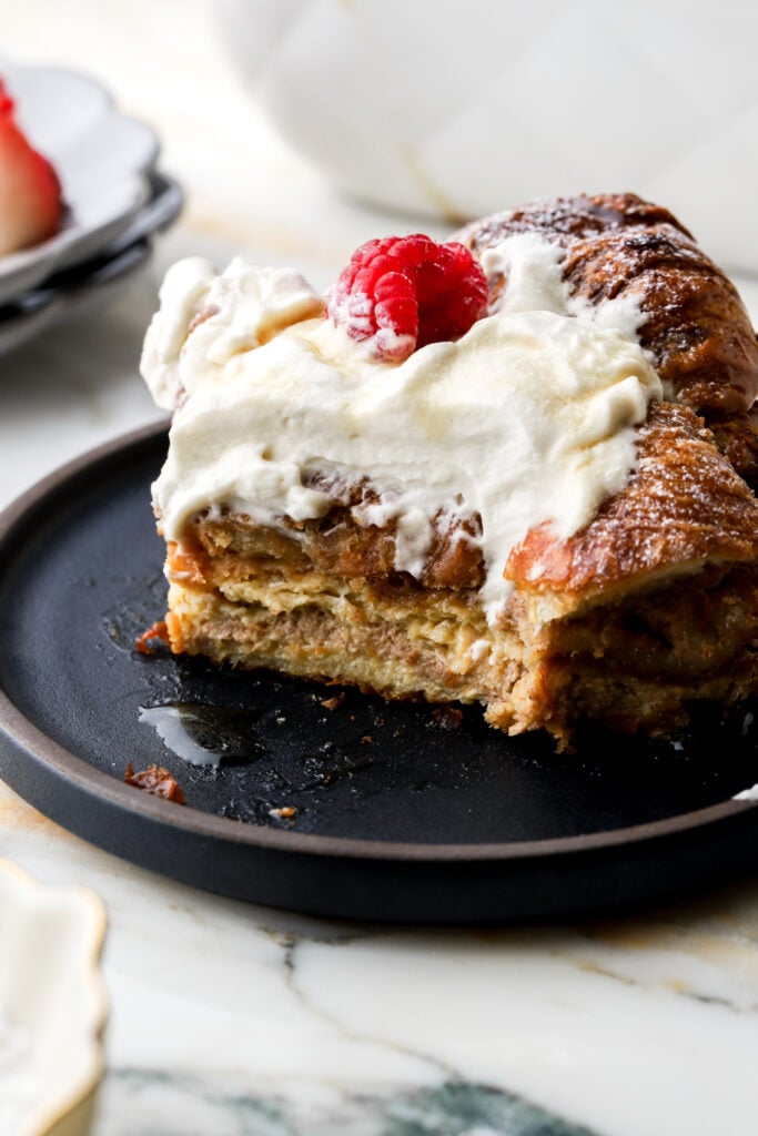 slice of french toast casserole on a plate topped with whipped cream