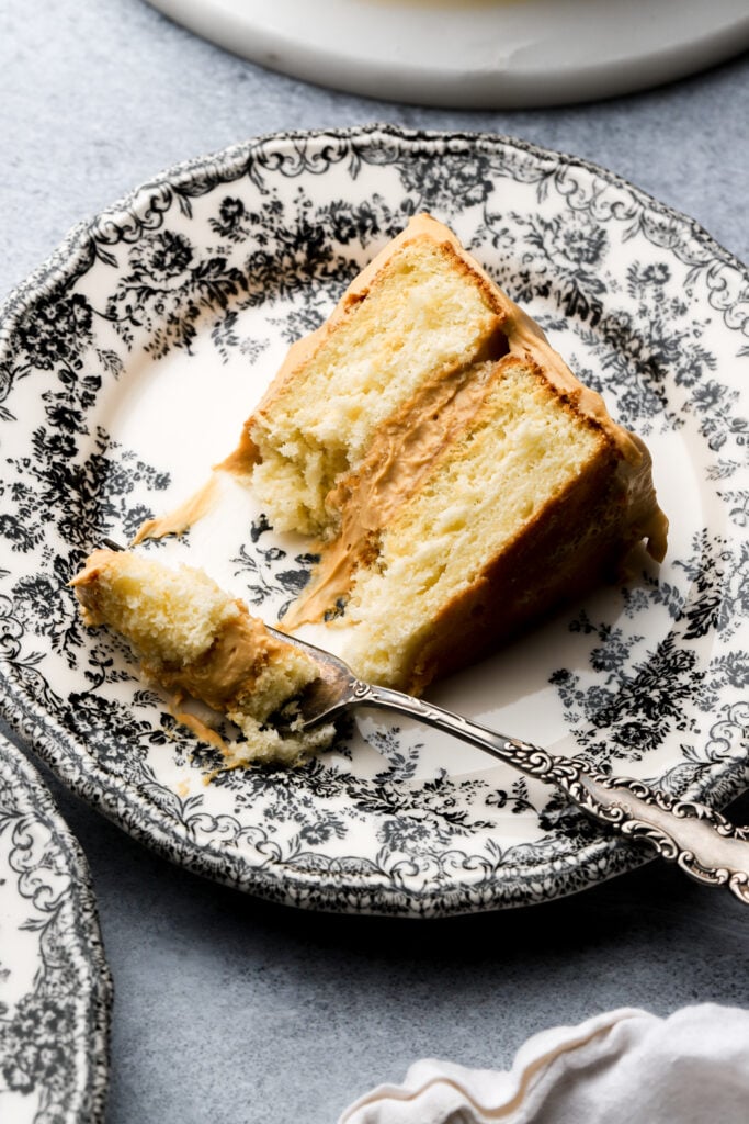 slice of dulce de leche cake on a plate with a bite taken out