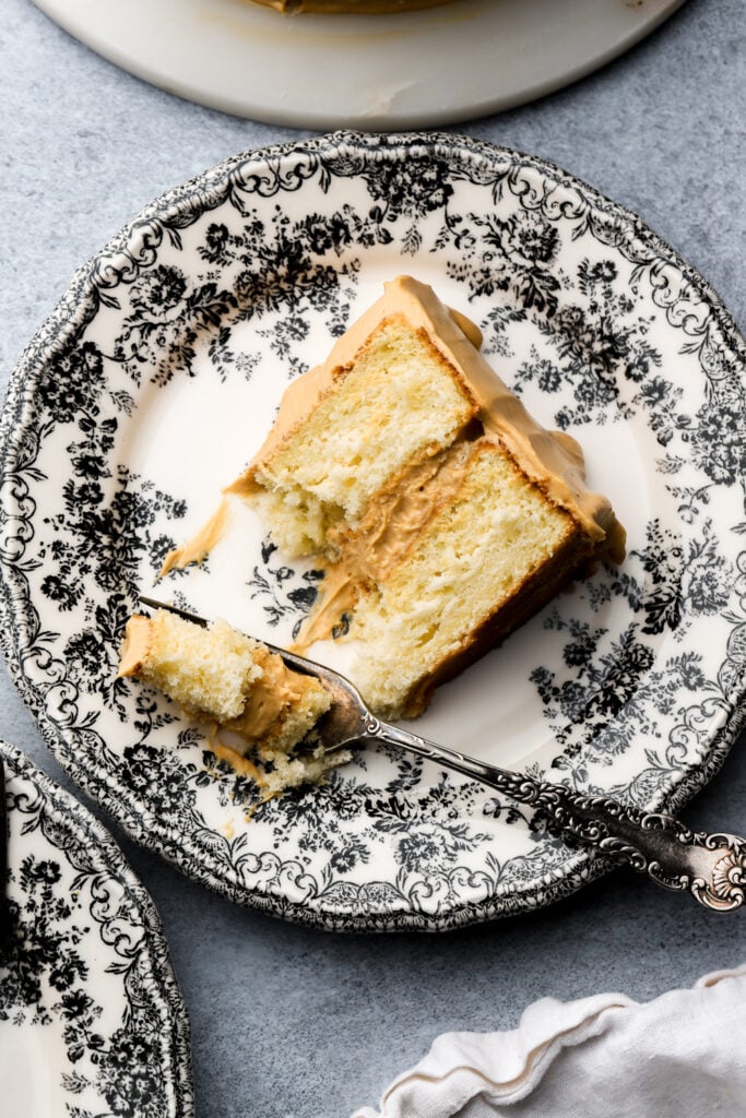 slice of dulce de leche cake on a plate with a bite taken out