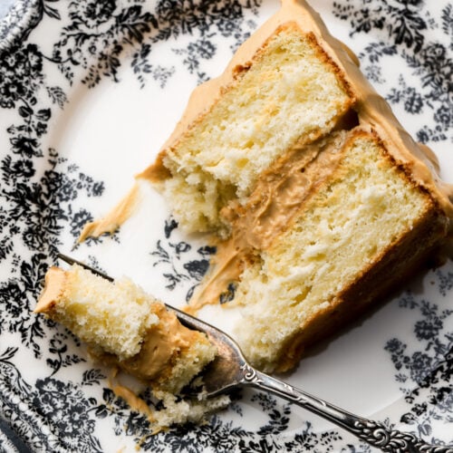 slice of dulce de leche cake on a plate with a bite taken out