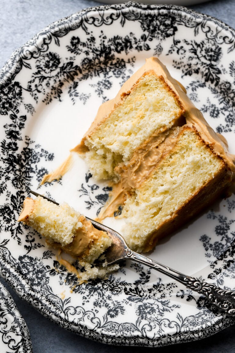 slice of dulce de leche cake on a plate with a bite taken out