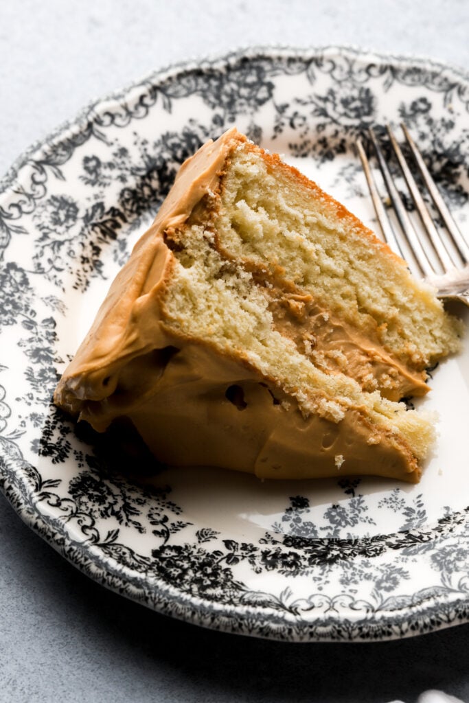 slice of dulce de leche cake on a plate with a bite taken out