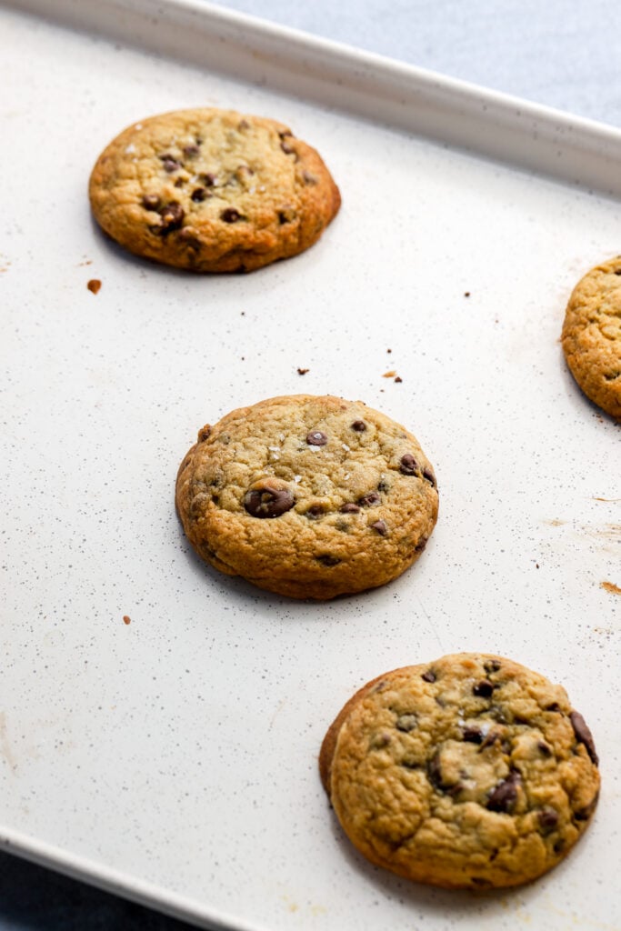 freshly baked chocolate chip cookies still on the baking sheet