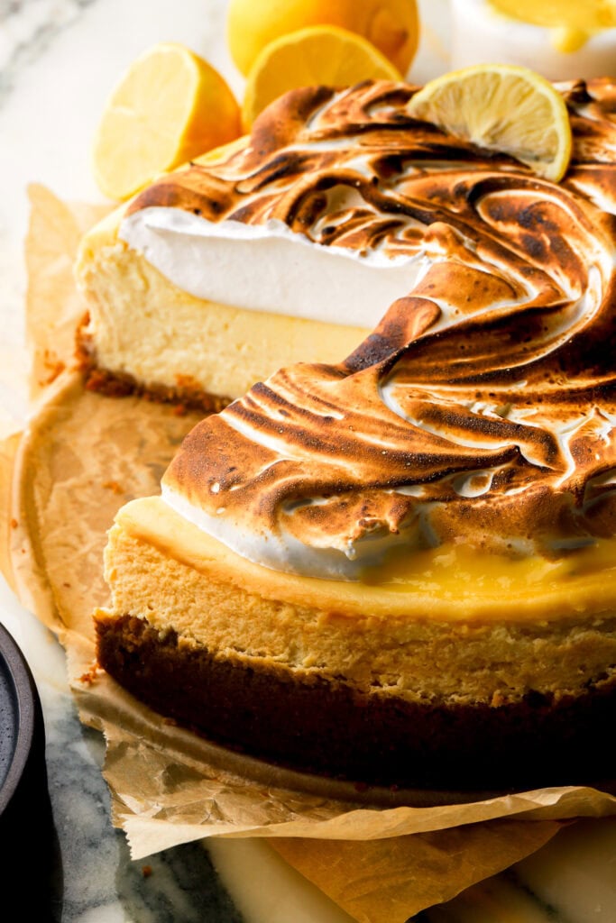 close up of lemon meringue cheesecake with a slice cut out
