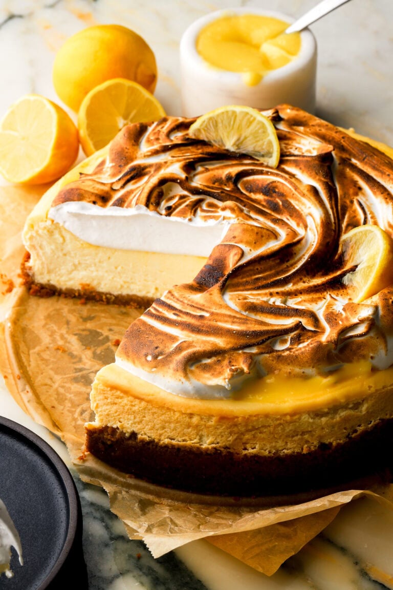 lemon meringue cheesecake with a slice cut out to show the inside
