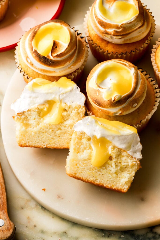 lemon meringue cupcakes cut in half with lemon curd dripping