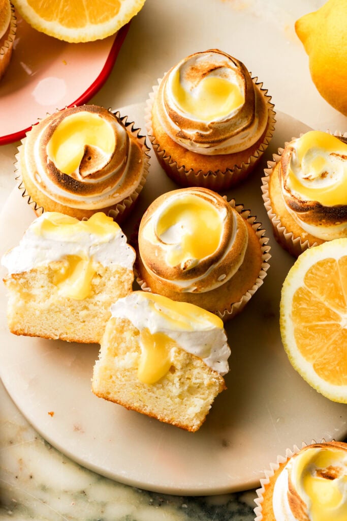 lemon meringue cupcakes cut in half with lemon curd dripping
