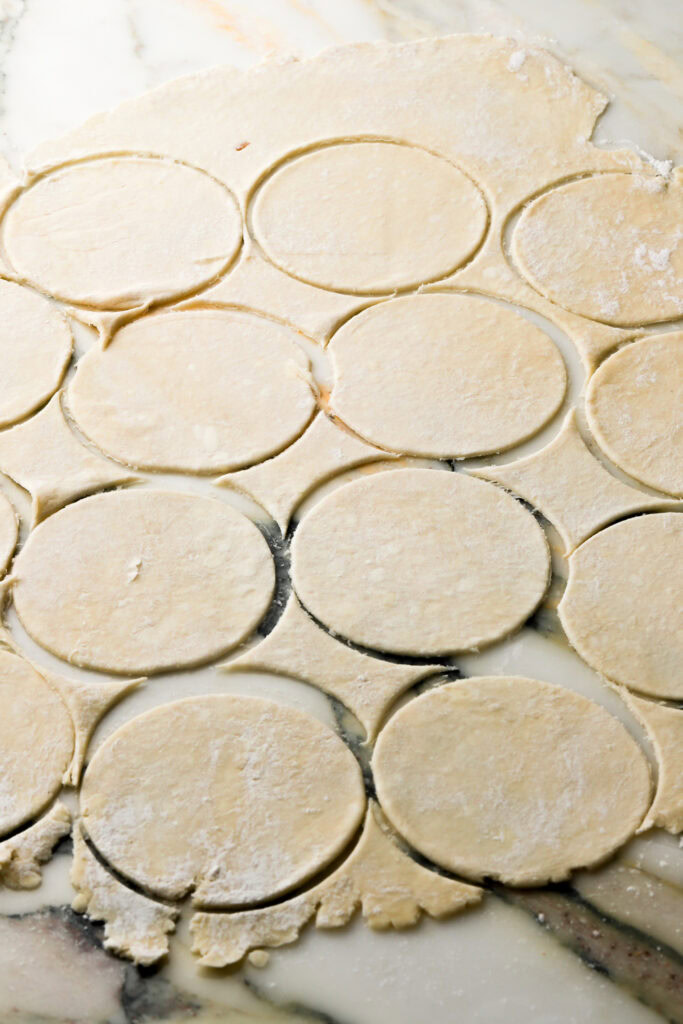 pie dough rolled out with 12 circles cut out